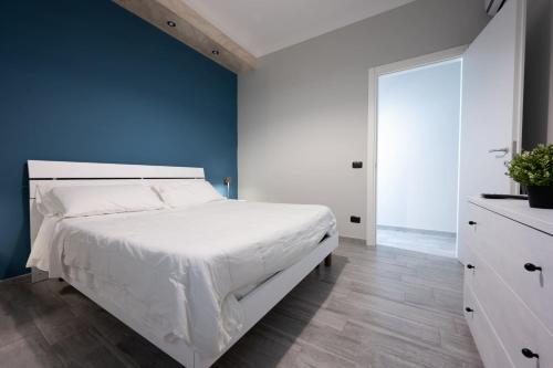 a bedroom with a white bed and a blue wall at B&B del Sole in Ercolano