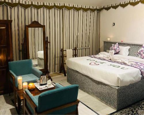 a bedroom with a bed and a chair and a table at Excellent Desert Safari camp in Sām