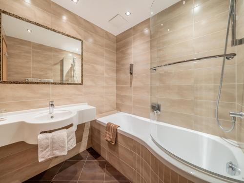 a bathroom with a tub and a sink and a mirror at Haus Annakogl und Haus Barbara in Obergurgl