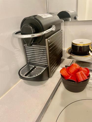 a coffee maker on a counter with a bowl of peppers at 渋谷駅徒歩10分!!一棟まるごと貸し切り!お子様歓迎駐車場無料10人ok5部屋バスルーム2つ in Tokyo
