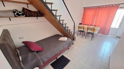 a living room with a bed and a staircase at Departamento "Tuti" in Libertador San Martín