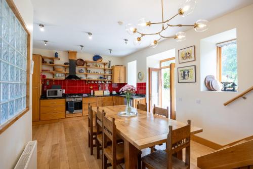 a kitchen with a wooden dining room table and chairs at The Coach House 5 star property in Inistioge