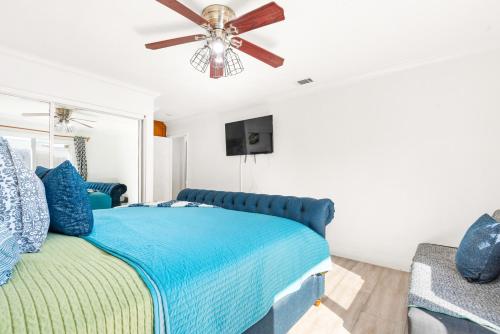 a bedroom with a blue bed and a ceiling fan at Gated 6beds 2garage home near Disney other LA attraction in Chino