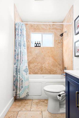 a bathroom with a toilet and a shower curtain at Gated 6beds 2garage home near Disney other LA attraction in Chino