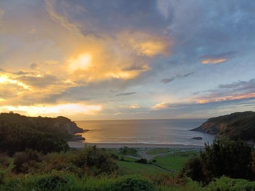 a view of the ocean from a hill with the sunset at casa maria in Barcia