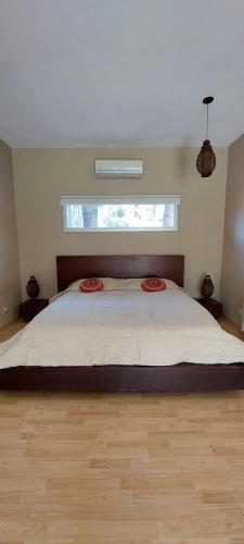 a bedroom with a large bed with a window at Casa SHANTI in Pinamar