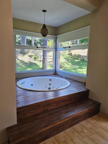 a large bath tub in a room with two windows at Casa SHANTI in Pinamar