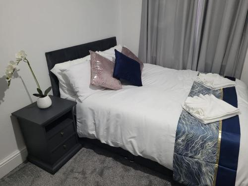 a bedroom with a bed with pillows and a night stand at Large 5 Bedrooms in Sheffield, Near City Centre & Parks in Nether Edge