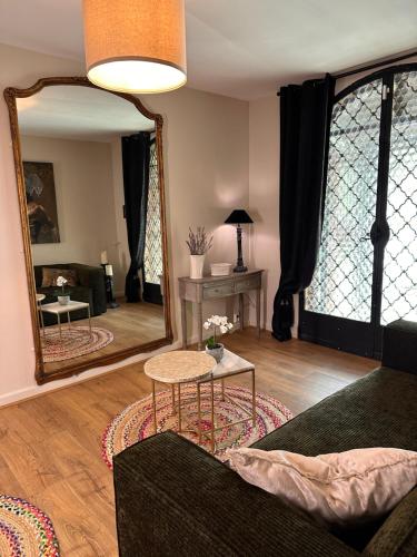 a living room with a mirror and a couch at Bastide Aïna SPA et piscine in Grasse
