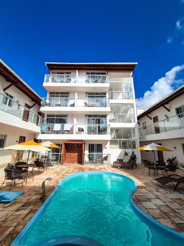 a hotel with a swimming pool in front of a building at Vila de Maré Hotel in Porto De Galinhas