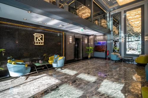 a lobby of a hotel with blue chairs and tables at Rusel Park Residence in Bahcesehir