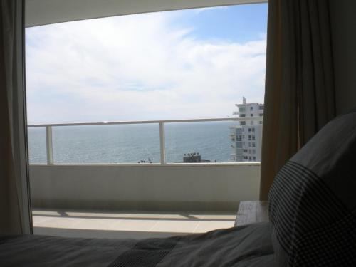 a bedroom with a view of the ocean from a window at Pacific Blue in Concón