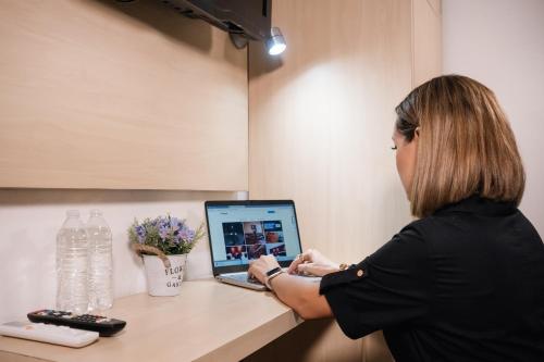 a woman sitting at a counter using a laptop computer at Hotel del Carmen, en el Centro- DESAYUNO Incluido ! in Tuxtla Gutiérrez
