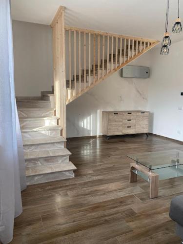 a living room with a staircase and a glass table at Relais Green Paradise in Apice