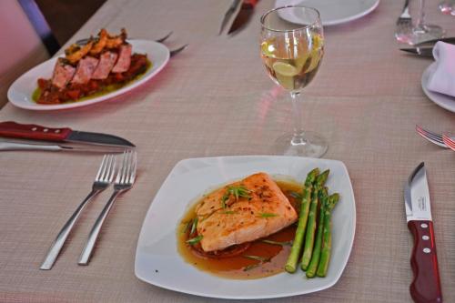 a table with two plates of food and a glass of wine at Hotel Posada Virreyes in Guadalajara