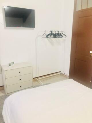 a white bedroom with a bed and a dresser at Private Room 201 in Guest House da Fonte in Figueira da Foz