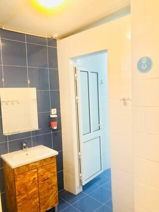 a bathroom with a sink and a door in a room at Private Room 201 in Guest House da Fonte in Figueira da Foz