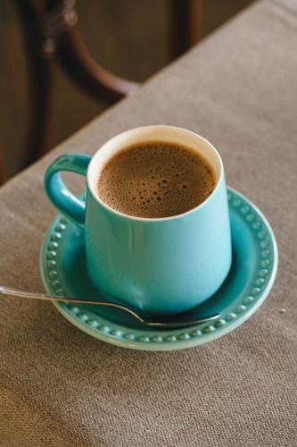 a blue cup of coffee on a plate on a table at Hotel Posada Virreyes in Guadalajara