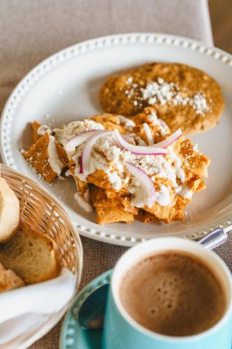 a plate of food with bread and a cup of coffee at Hotel Posada Virreyes in Guadalajara