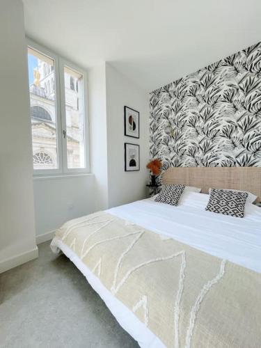 une chambre blanche avec un grand lit et une fenêtre dans l'établissement Studio Vieille Ville - 300m du Lac, à Annecy