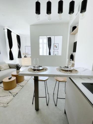 Cette chambre blanche dispose d'une table, de chaises et d'un canapé. dans l'établissement Studio Vieille Ville - 300m du Lac, à Annecy