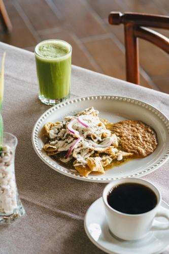 a plate of food and a cup of green juice at Hotel Posada Virreyes in Guadalajara