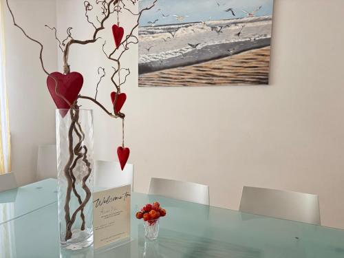 a glass vase with red hearts on a table at Villa Azzurro Blu in Lignano Sabbiadoro