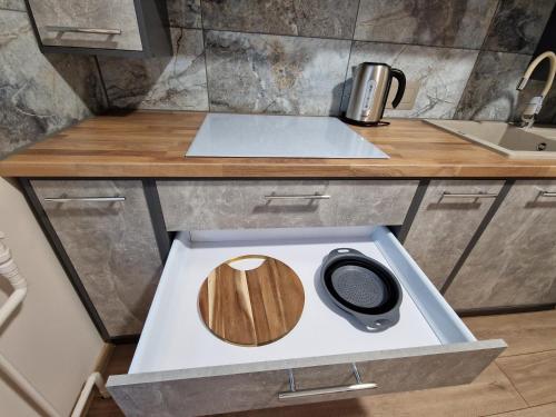 a kitchen counter with a wooden cutting board on it at Cēsu Mājas Akmens ielā in Cēsis