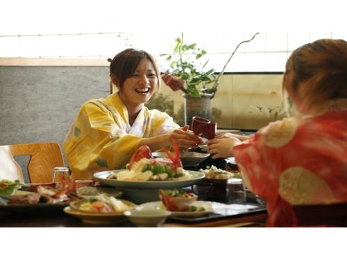 two women sitting at a table eating food at Inatori Tokai Hotel Yuen - Vacation STAY 31868v in Inatori