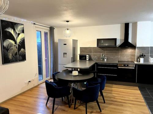 une cuisine avec une table et des chaises dans une pièce dans l'établissement Suite Sanctuaire à Lourdes, à Lourdes