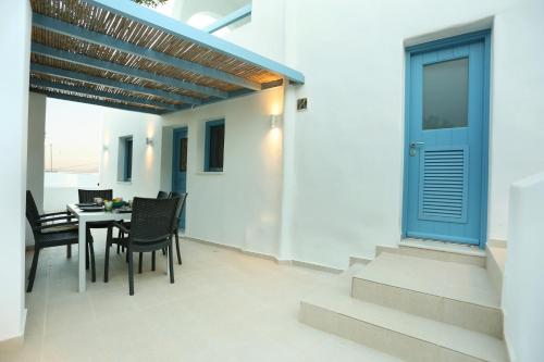a dining room with a table and chairs and a blue door at E & I Lefkes Studio Paros in Lefkes