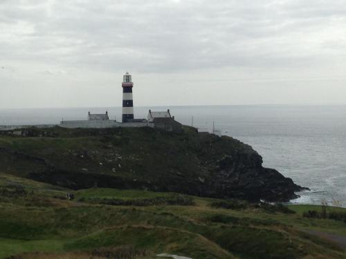 a lighthouse on a hill next to the ocean at Kinsale in Kinsale