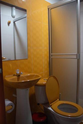 a bathroom with a sink and a toilet and a mirror at Home Sweet Home in Pitalito