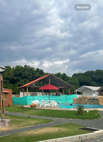 a swimming pool with two white chairs and a pavilion at Eco Cabañas Montana in Santa Helena