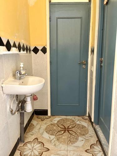 a bathroom with a sink and a blue door at Magic View in Bine el Ouidane