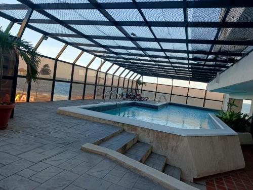 ポルラマルにあるMENINA Beach Apartmentの屋根付きの建物内の大型スイミングプール