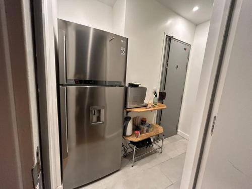 une cuisine avec un réfrigérateur en acier inoxydable dans une pièce dans l'établissement Paris 2Pièces 2 salles de bain, à Paris
