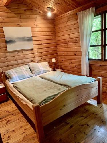a bedroom with a bed in a log cabin at Ferienhaus Schnuckenheide 13 in Winsen