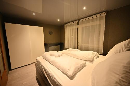 バーデン・バーデンにあるGemütliche 2Zimmer Wohnung Zentrums und Bahnhofnahのベッドルーム1室(白いシーツが備わるベッド2台、窓付)