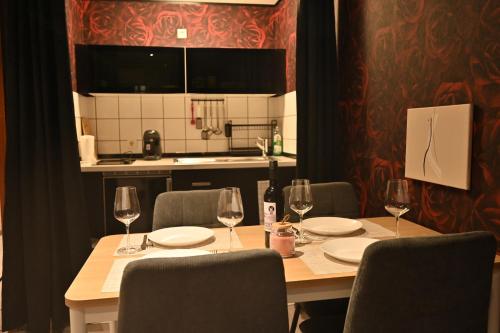 バーデン・バーデンにあるGemütliche 2Zimmer Wohnung Zentrums und Bahnhofnahのテーブル(椅子付)、ワイングラス