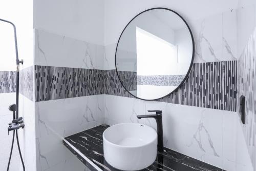 a bathroom with a round mirror and a sink at Belvedere Thoddoo in Thoddoo