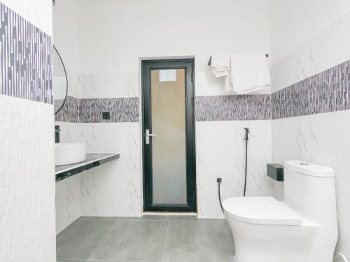 a white bathroom with a toilet and a sink at Belvedere Thoddoo in Thoddoo