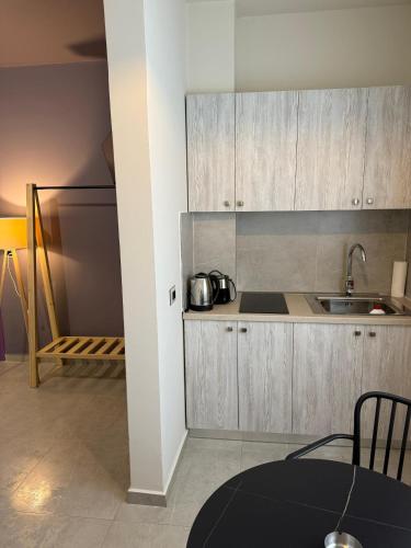 a kitchen with wooden cabinets and a sink at STAY-FIVE rooms & apartments in Shkodër