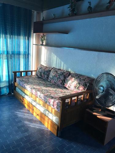 a bed in a room with a fan and a window at Departamentos frente al mar-Villa Gesell in Villa Gesell