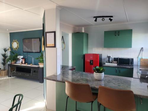 a kitchen with green cabinets and a red refrigerator at The Legacy BnB in East London