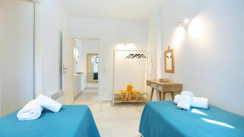 a bedroom with two beds and a desk and a sink at E & I Lefkes Studio Paros in Lefkes