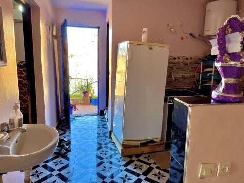 a bathroom with a white refrigerator and a sink at Magic View in Bine el Ouidane
