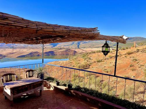 a porch with a bench and a view of a lake at Magic View in Bine el Ouidane