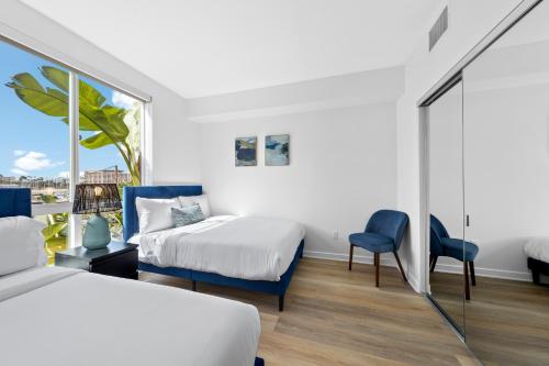 een slaapkamer met twee bedden en een raam bij The Turquoise Lounge - Chic 2BR Beach view Pool, Sauna in Los Angeles