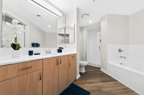 een badkamer met een wastafel, een toilet en een bad bij The Turquoise Lounge - Chic 2BR Beach view Pool, Sauna in Los Angeles